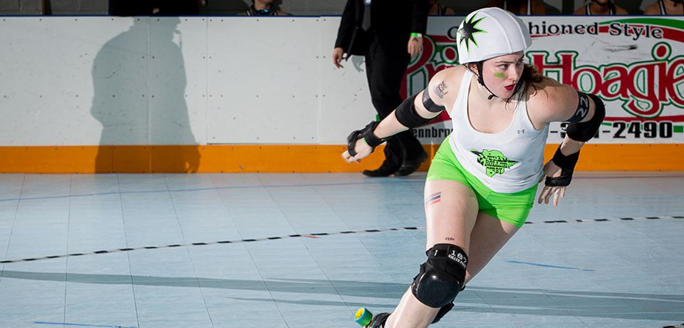 A jammer skates around a roller derby track